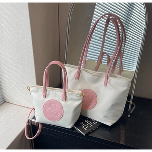 Detalle del bolso tote de nailon blanco y bolso de mano con adornos en rosa
