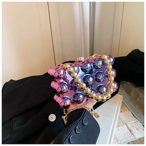 Detail of gradient acrylic clutch with metallic spheres and gold beaded handle