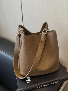 Braune Eimer-Tasche aus Litschileder mit breitem Gurt und goldener Hardware für Damen