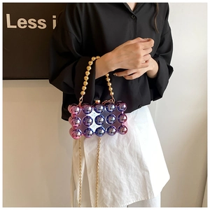 Detail of purple-blue gradient acrylic evening bag with 3D bubble texture and gold bead handle
