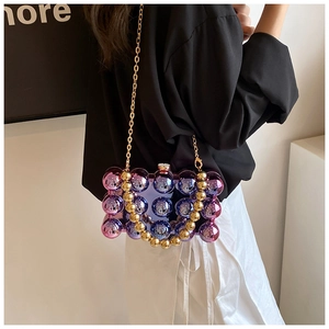 Detail of gradient blue and purple beaded spherical bag with gold beaded top handle and chain