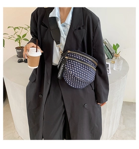 Detail of blue and white geometric saddle bag with wide strap and double zippers
