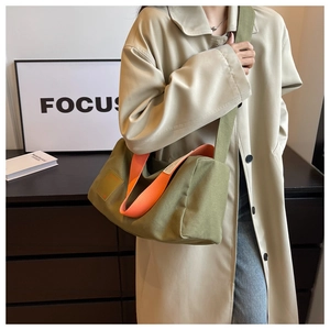 Detail of army green canvas tote bag with orange lining and wide shoulder strap