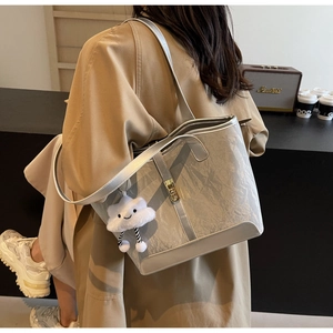Detail of silver metallic tote bag with shoulder straps and cloud plush charm