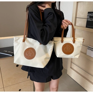 Comparación de bolsos tote de nailon beige grandes y pequeños con asas de cuero marrón
