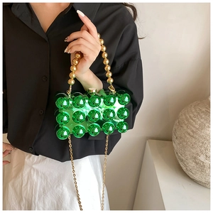 Detail of green acrylic evening bag with 3D bubbles and golden bead handle