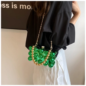 Crossbody view of green acrylic bubble clutch bag with gold chain and beaded handle