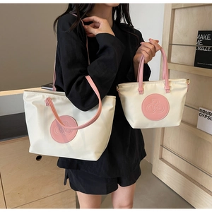 Detalle del conjunto de bolso tote blanco roto y rosa con asas de piel y textura fina