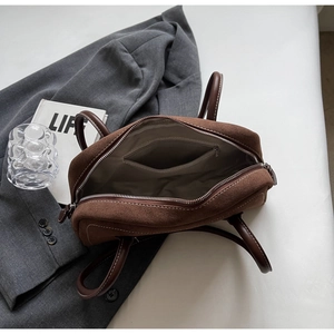 Interior view of brown suede handbag showing fabric lining and inner zipper pocket