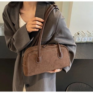 Detail view of the brown frosted suede texture and refined stitching of the baguette bag