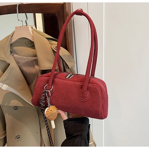 Detail of burgundy matte leather boston bag with logo embossing and strawberry charm