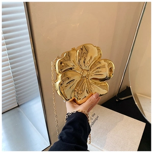 Close-up of golden flower shaped evening bag with reflective metallic finish and chain