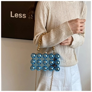 Detail of blue acrylic evening bag with 3D bubble relief and gold beaded handle