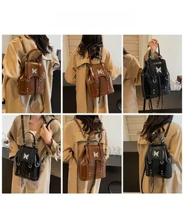 Close-up of small vintage faux leather backpack with silver butterfly detail in black and brown