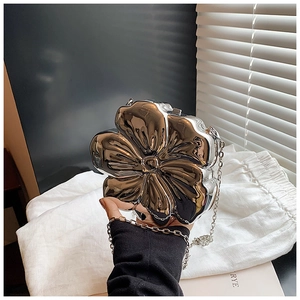 Detail of silver metallic flower evening bag with a delicate chain strap for women