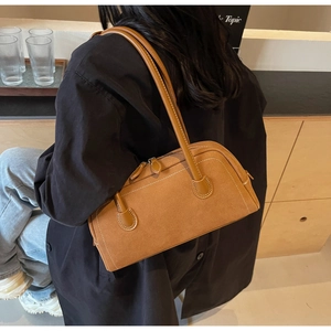 Detail of caramel suede bag featuring white contrast stitching and long leather handles