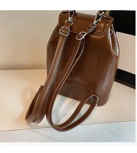 Detail of adjustable straps and glossy brown leather on a chic butterfly backpack