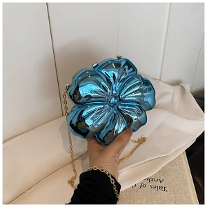 Detailed shot of flower-shaped clutch in metallic blue with a delicate gold chain strap