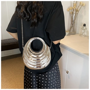 Detailed close-up of metallic silver acrylic shell clutch bag with stylish ring handle