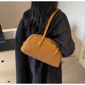Detailed view of brown suede style shoulder bag showing soft matte texture and dual handles