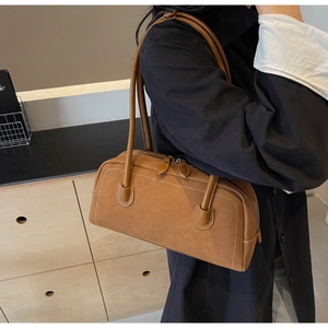 Detail of brown faux suede shoulder bag with contrast stitching and dual zippers