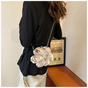 Close-up of a silver flower-shaped evening clutch bag with a metallic chain strap