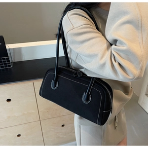 Detail of black matte bag featuring white contrast stitching and slim shoulder straps