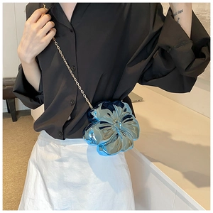 Detail of blue flower evening bag with metallic finish and gold chain strap