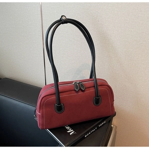 Detail of vintage burgundy baguette bag with white contrast stitching and dual zippers