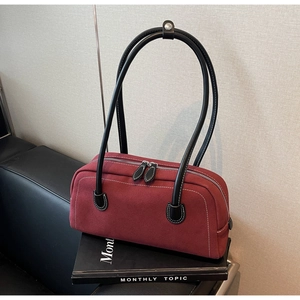 Detail of vintage red baguette bag featuring white contrast stitching and sleek black straps