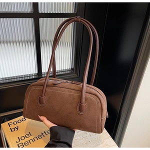 Detail view of dark brown suede bag with retro contrast stitching and double zippers