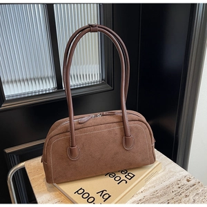 Detail of vintage brown suede baguette bag with contrast stitching and dual zippers