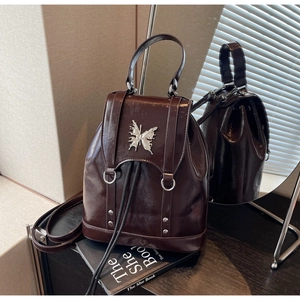 Detail of burgundy glossy leather backpack with silver butterfly buckle and drawstring