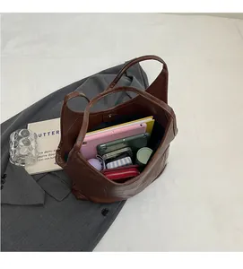 Top-down view of a spacious brown checkered tote bag interior with tablets and wallets