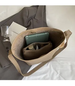 Detailed internal view of large capacity tote bag showing laptop and inner pouch storage
