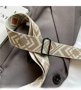Close-up of adjustable woven shoulder strap with green orange geometric patterns and black buckle