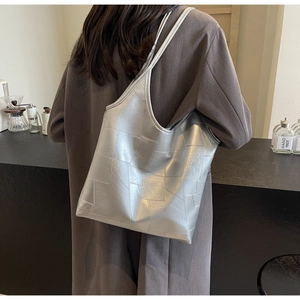 Detailed view of large silver tote bag with unique geometric patchwork and metallic finish