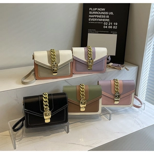 Detail of five multi-colored crossbody small square bags with gold chains and buckles