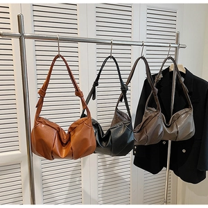 Detail of soft leather crossbody bags with ruched texture and knotted shoulder strap