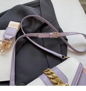 Detail of color-block crossbody bag with gold chain and dual texture shoulder straps