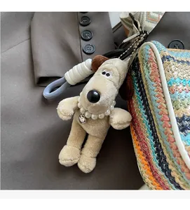 Detailed shot of a plush dog charm with pearl necklace on a colorful woven handbag