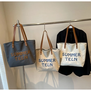 Détail de sacs cabas en toile avec poignées en cuir et broderie Summer Teln