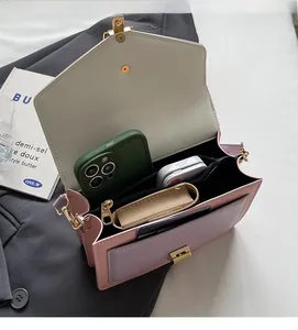 Internal view of a multi-compartment pink and lilac shoulder bag showing spacious storage