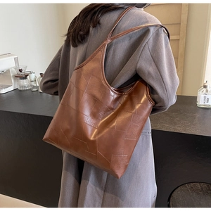 Detail of vintage brown tote bag with irregular patchwork and high-quality leather texture