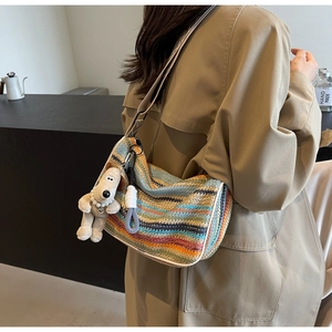 Colorful woven crossbody bag with striped pattern and plush puppy charm detail