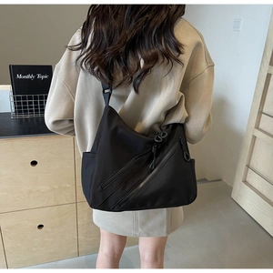 Detailed back view of a black nylon crossbody tote bag showing adjustable shoulder strap