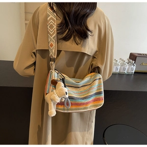 Detail of bohemian knit crossbody bag with multi-color stripes and jacquard strap