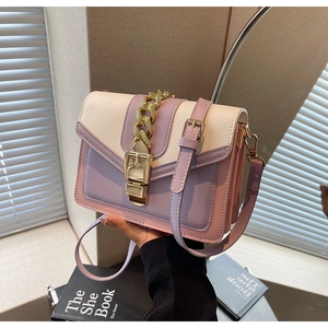 Detail of multi-color crossbody bag featuring gold chain decor and leather strap