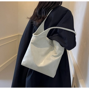 Detail of off-white leather tote bag with geometric stitching and magnetic closure