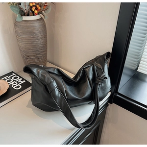 Detail of black soft PU leather hobo bag showing fine grain texture and silver metal zipper